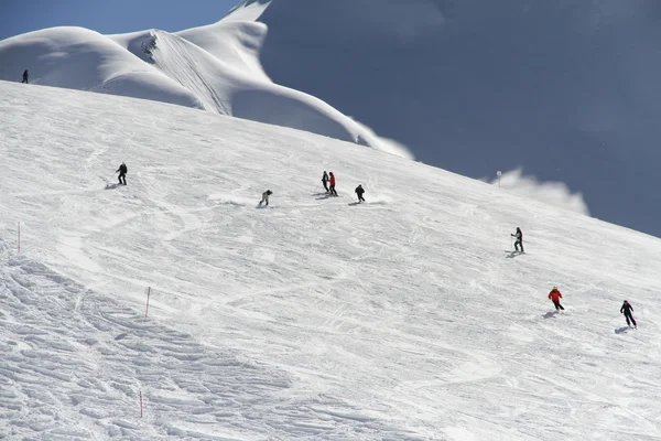 Esquiadores descendo a encosta na estância de esqui — Fotografia de Stock