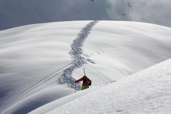 雪に覆われた山に登るスキーヤー — ストック写真