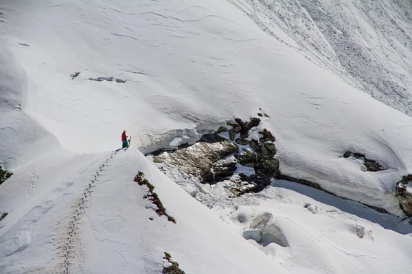 Skiër een besneeuwde berg klimmen — Stockfoto