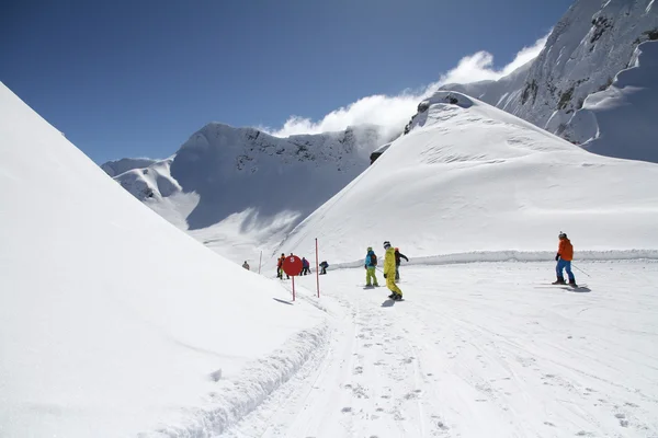 Skiers going down the slope at ski resort — Stock Photo, Image