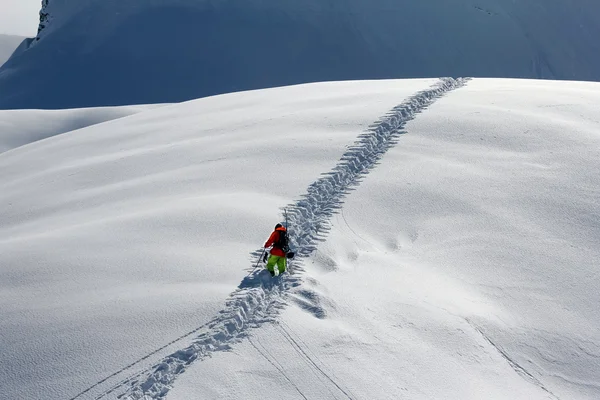 Лыжник взбирается на снежную гору — стоковое фото