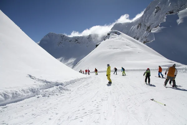Esquiadores bajando la pista en la estación de esquí —  Fotos de Stock