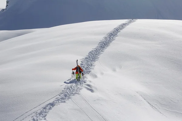 Esquiador escalando una montaña nevada —  Fotos de Stock