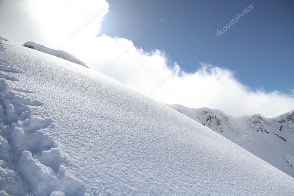 Ski slope in powder snow, mountain landscape