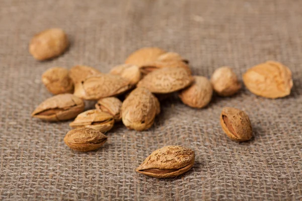 Almonds nuts on sackcloth — Stock Photo, Image