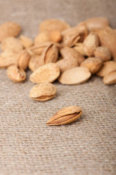 Almonds nuts on sackcloth — Stock Photo, Image