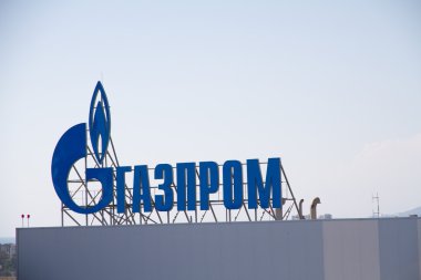 ADLER, RUSSIA - JUNE 26, 2013: Gazprom company logo on the roof of thermal power plant. clipart