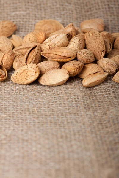 Almonds nuts on sackcloth — Stock Photo, Image