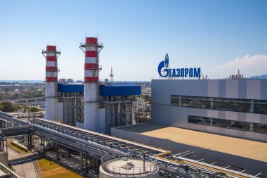 ADLER, RUSSIA - JUNE 26, 2013: Gazprom company logo on the roof of thermal power plant. clipart