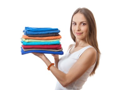 Young woman holding a pile of clothes