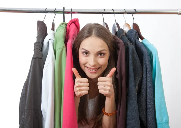 Jonge vrouw in de buurt van rack met hangers — Stockfoto