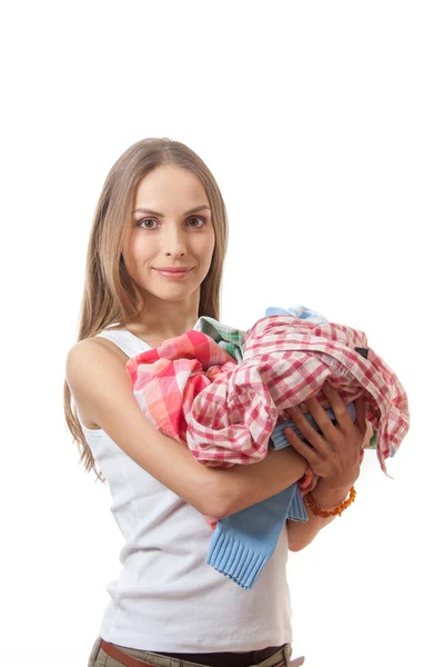 Junge Frau mit einem Stapel Kleidung — Stockfoto