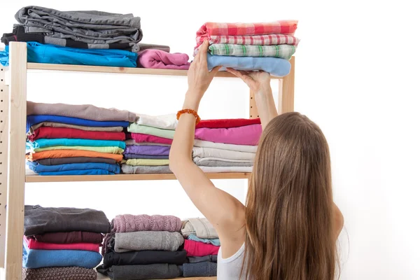 Young woman holding a pile of clothes — Stock Photo, Image