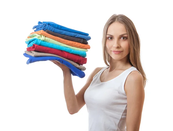 Jeune femme tenant une pile de vêtements — Photo