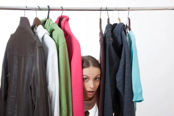 Jonge vrouw in de buurt van rack met hangers — Stockfoto