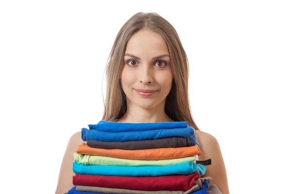 Mujer joven sosteniendo una pila de ropa — Foto de Stock