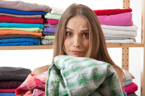 Young woman holding a pile of clothes — Stock Photo, Image