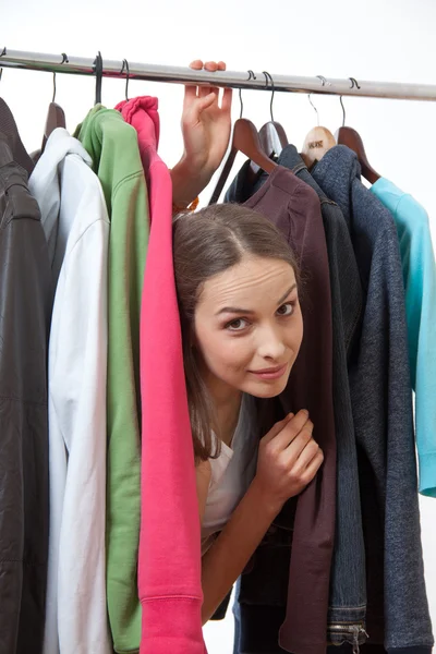 Young woman near rack with hangers — Stock Photo, Image