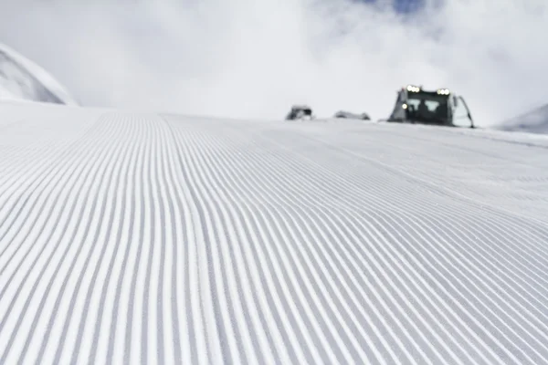 Φρέσκο χιόνι groomer κομμάτια σε μια πίστα — Φωτογραφία Αρχείου