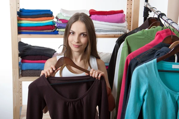 Mujer joven elige ropa — Foto de Stock