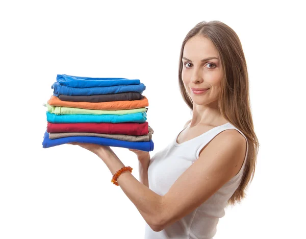 Young woman holding a pile of clothes — Stock Photo, Image