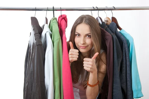 Jonge vrouw in de buurt van rack met hangers — Stockfoto