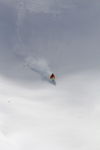 Лыжник в глубоком порошке, экстремальный фрирайд
