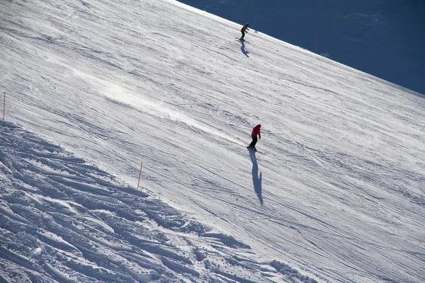 Skiërs naar beneden de helling in skiresort. — Stockfoto