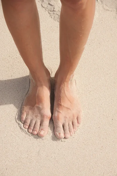 Womens voeten in het zand — Stockfoto