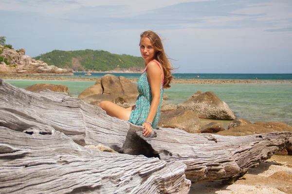 Chica en vestido sentado en una roca junto al mar —  Fotos de Stock