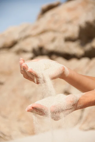 Sand flyter genom de kvinnliga händerna — Stockfoto