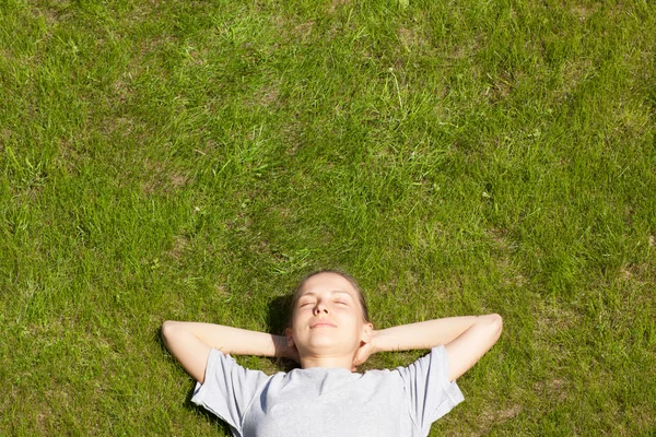 Jong meisje liggen op het gras — Stockfoto