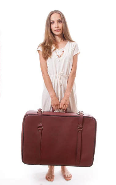 Woman lifts a heavy suitcase, isolated on white — Stock Photo, Image