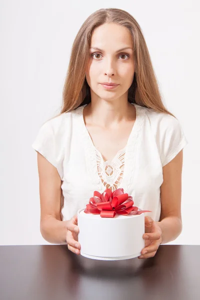 Wanita muda dan kotak hadiah bulat di atas meja — Stok Foto