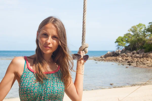 Meisje spelen de schommel op strand — Stockfoto