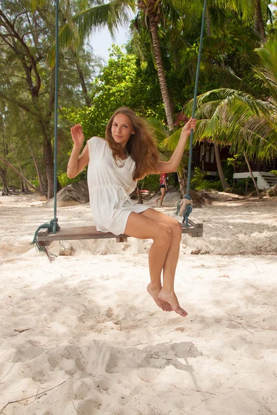 Meisje spelen de schommel op strand — Stockfoto