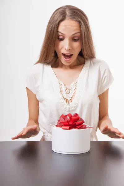 Giovane donna e scatola regalo rotonda sul tavolo — Foto Stock