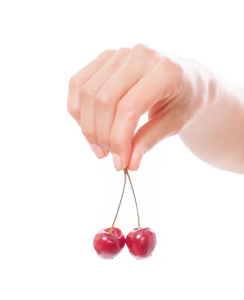 Mano sosteniendo dos cerezas sobre fondo blanco — Foto de Stock