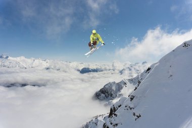Dağlarda zıplayan bir kayakçı. Dağ kayağı, kış ekstrem spor.