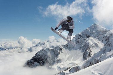 Dağlarda atlayan bir snowboardcu. Snowboard, kış sporu.