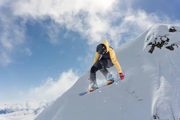 Ein springender Snowboarder in den Bergen. Snowboard, Winter Extremsport. Stockfoto