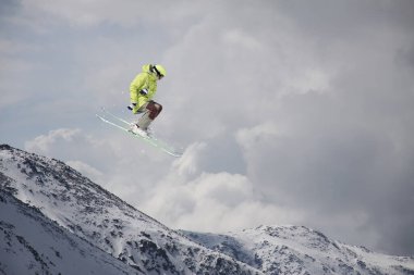 Dağlarda zıplayan bir kayakçı. Dağ kayağı, kış ekstrem spor.
