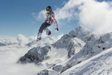 Dağlarda atlayan bir snowboardcu. Snowboard, kış sporu.
