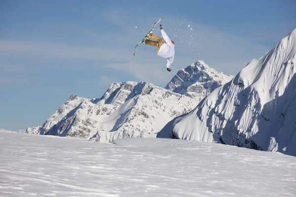 Um esquiador a saltar nas montanhas. Esqui de montanha, inverno esporte extremo. — Fotografia de Stock