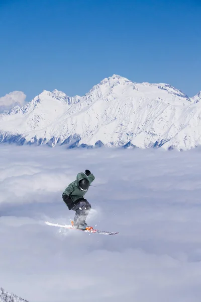 A jumping skier in the mountains. Mountain ski, winter extreme sport. — Stock Photo, Image