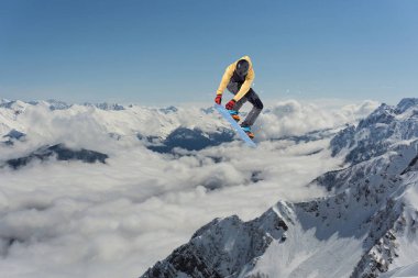 Dağlarda atlayan bir snowboardcu. Snowboard, kış sporu.