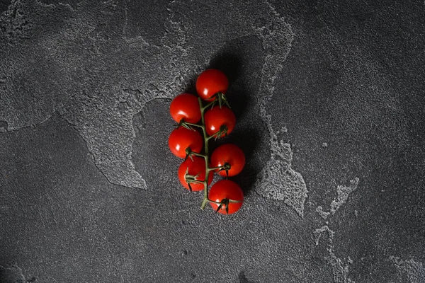 Beton arka planda bir dalda olgun kiraz domatesleri. Üst görünüm, alanı kopyala. — Stok fotoğraf