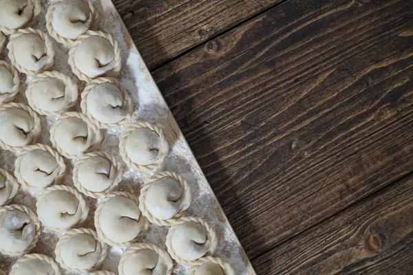 Carne o albóndigas vegetarianas, pelmeni en una tabla de madera. Comida nacional rusa. Vista superior cercana con espacio de copia. — Foto de Stock