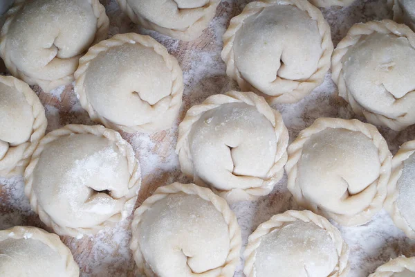 Carne o albóndigas vegetarianas, pelmeni en una tabla de madera. Comida nacional rusa. Vista superior cercana. — Foto de Stock