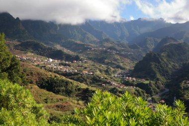 The green Southern surroundings of Sao Vicente, located in the North of Madeira Island, Portugal, with terraced fields and mountains in the background
